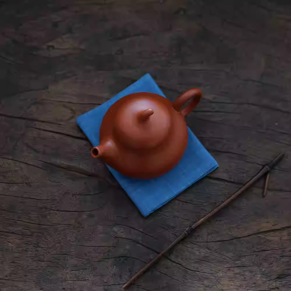 Japanese Indigo Tea Cloth – Hand-Dyed Cotton Linen placed under a traditional brown teapot on wooden surface