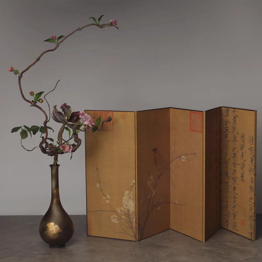 Rin Essense folding screen style home decor with traditional artwork displayed beside a vase with flowering branches