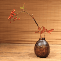 Rin Essense wood vase with rustic dark grain holding autumn leaves and red berries on wooden surface