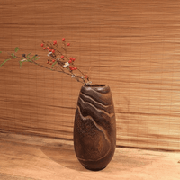 Rin Essense wood vase with natural grain pattern holding delicate red berries and green leaves on wooden surface