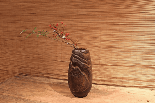 Rin Essense wood vase with natural grain pattern holding delicate red berries and green leaves on wooden surface