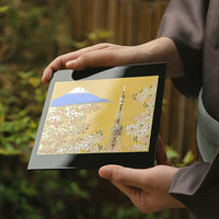 Yamanaka Lacquerware Makie Coaster with Mount Fuji and cherry blossom design held by person in traditional attire